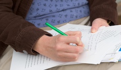 A student writes notes on a piece of paper.
